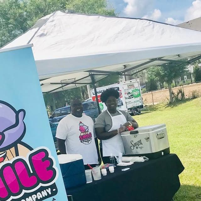 Glen and the Smile Ice Cream team running their pop-up booth outdoors under a branded tent